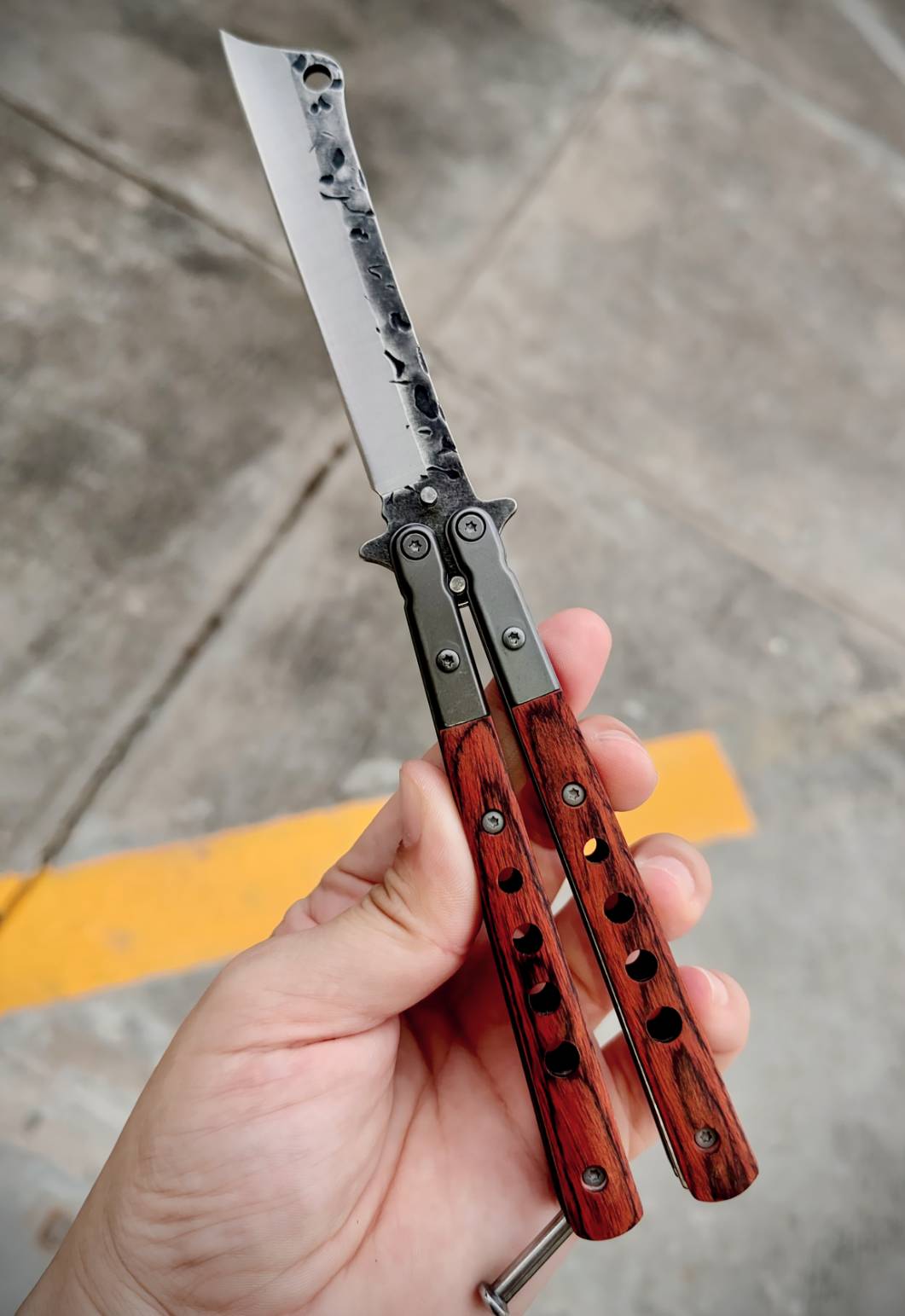 มีดควงบาลิซอง ทรงใบคัตติ้งปลายเฉียบ ไล่ลวดลายผิวใบแบบตีผิวดิบ ดูมีเอกลักษณ์ ด้ามผสมสแตนเลส + ไม้ ให้ฟีลแข็งแรงแต่ยังจับสบายมือ ตัวด้ามจับแน่น ไม่คลอนง่าย มีน๊อตยึดอย่างดี เวลาหมุนแล้วคุมจังหวะได้ดี น้ำหนักสมดุล ขนาดพอดีมือ ใช้โชว์ก็เท่ห์ ใช้งานก็ลงตัว