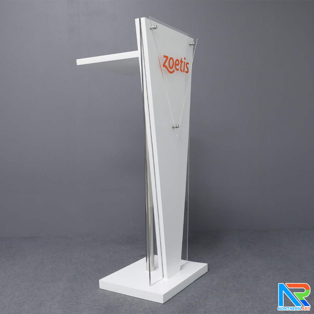 โพเดียมไม้สีขาว ทรงสามเหลี่ยม ขนาด (W) 45 x (L) 35 x (H) 120 cm. ด้านข้างอะคริลิคใส หนา 8 มม. ด้านหน้าอะคริลิคใส ติดหมุด สำหรับติดโลโก้