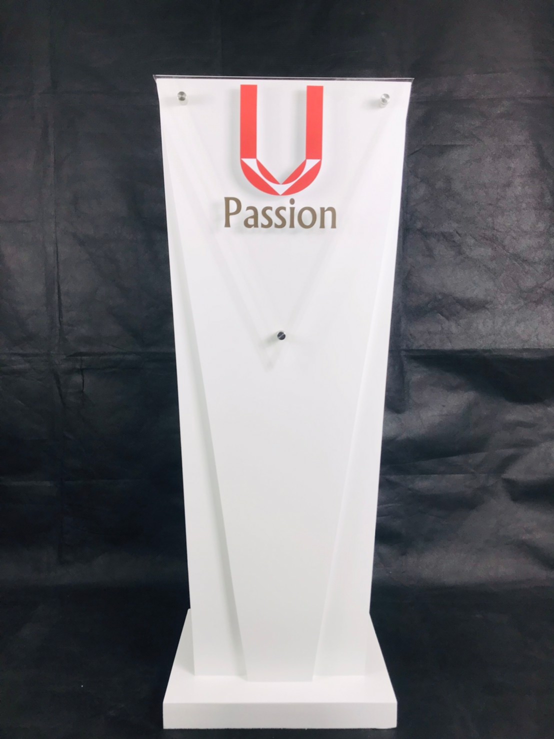 โพเดียมไม้สีขาว ทรงสามเหลี่ยม ขนาด (W) 45 x (L) 35 x (H) 118 cm. ด้านหน้าอะคริลิคใส ติดหมุด สำหรับติดโลโก้