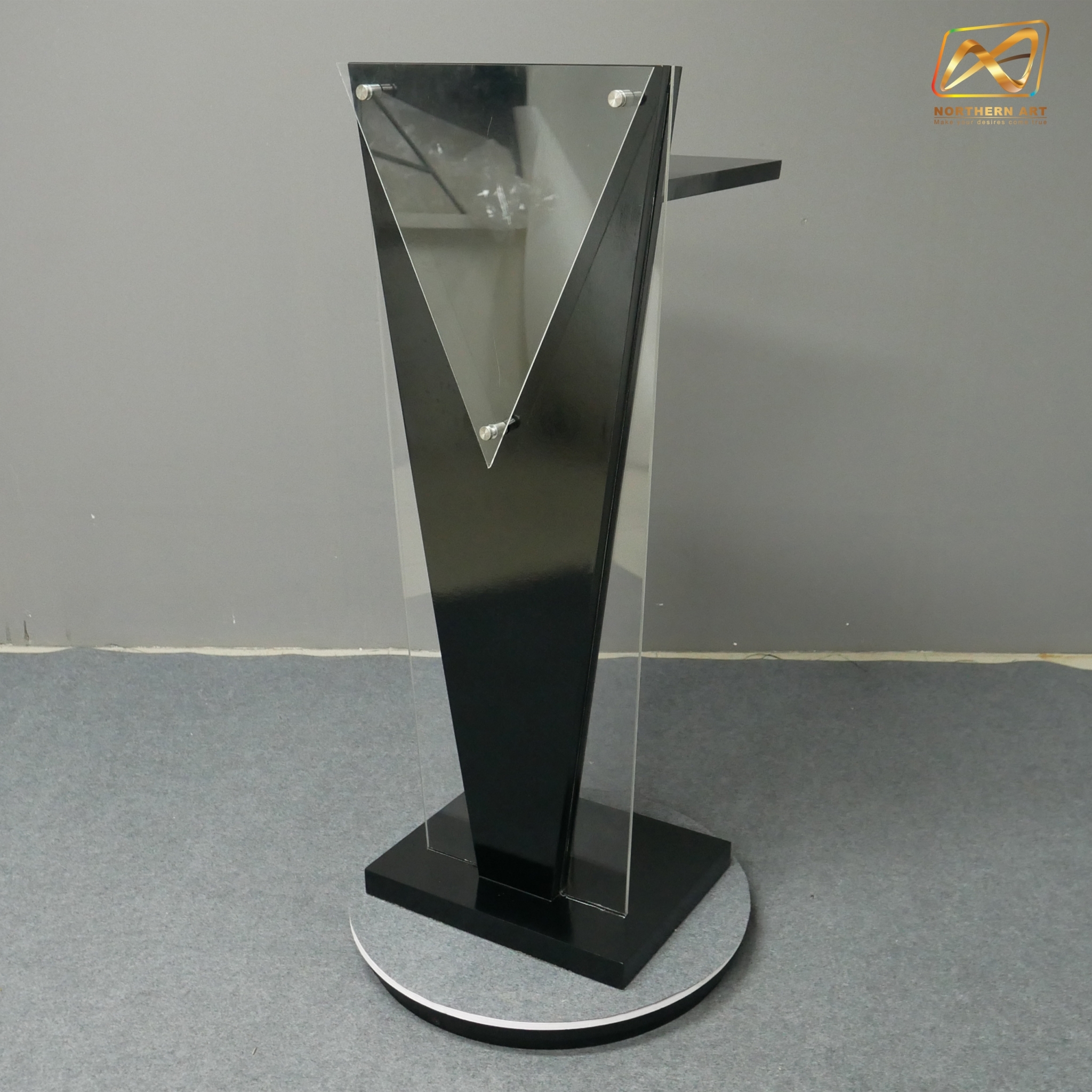โพเดียมไม้สีดำ ทรงสามเหลี่ยม ขนาด (W) 45 x (L) 35 x (H) 120 cm. ด้านข้างอะคริลิคใส หนา 8 มม. ด้านหน้าอะคริลิคใส ติดหมุด สำหรับติดโลโก้