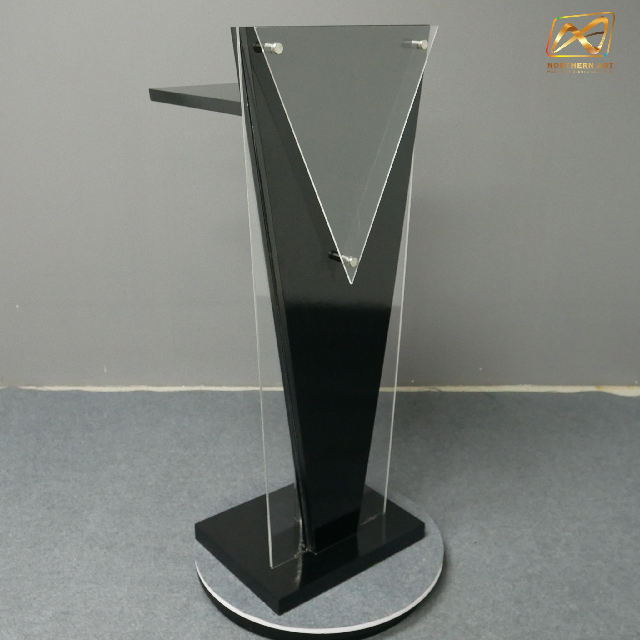 โพเดียมไม้สีดำ ทรงสามเหลี่ยม ขนาด (W) 45 x (L) 35 x (H) 120 cm. ด้านข้างอะคริลิคใส หนา 8 มม. ด้านหน้าอะคริลิคใส ติดหมุด สำหรับติดโลโก้