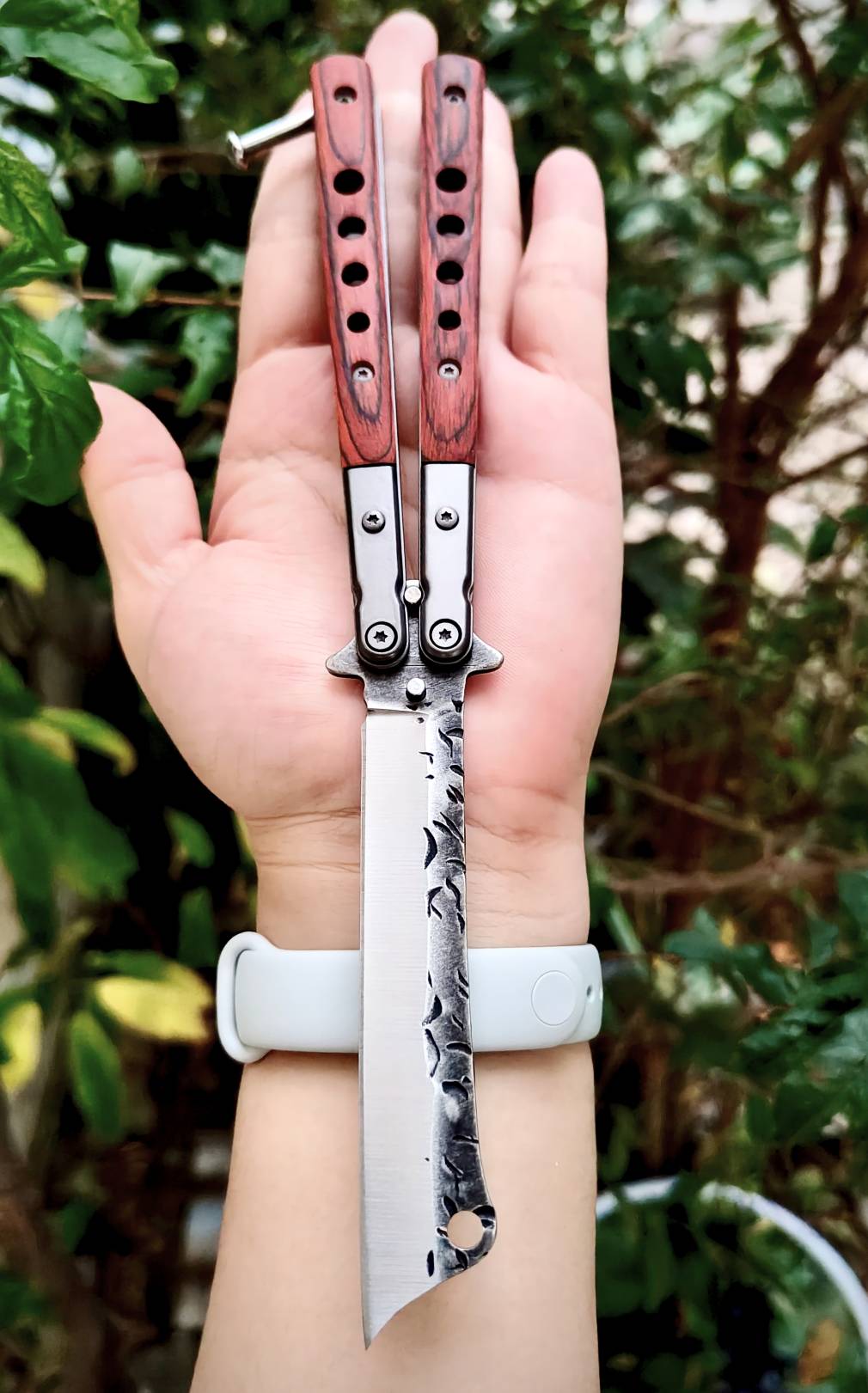 มีดควงบาลิซอง ทรงใบคัตติ้งปลายเฉียบ ไล่ลวดลายผิวใบแบบตีผิวดิบ ดูมีเอกลักษณ์ ด้ามผสมสแตนเลส + ไม้ ให้ฟีลแข็งแรงแต่ยังจับสบายมือ ตัวด้ามจับแน่น ไม่คลอนง่าย มีน๊อตยึดอย่างดี เวลาหมุนแล้วคุมจังหวะได้ดี น้ำหนักสมดุล ขนาดพอดีมือ ใช้โชว์ก็เท่ห์ ใช้งานก็ลงตัว