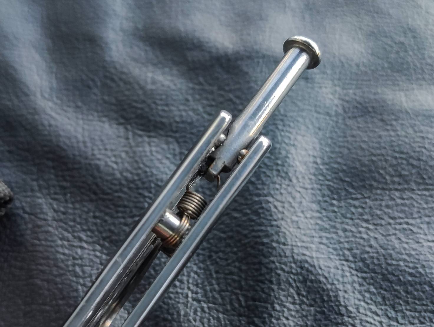 มีดบาลีซอง TK Tech มีดบาลิซองสไตล์เอเชีย ใบมีดเป็นทรงกริชสีเงิน ด้ามจับเป็นสแตนเลสฉลุลายสีเงินวาววับ จุดเด่นอยู่ที่ท้ายด้ามจับมีระบบสปริงแร็พ ทำให้หมุดล็อคด้ามไม่แกว่งไปมาในขณะเล่น จึงทำให้มิติของการควงสมดุล มาพร้อมซองไนล่อน