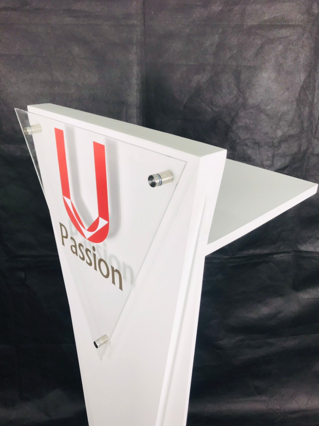 โพเดียมไม้สีขาว ทรงสามเหลี่ยม ขนาด (W) 45 x (L) 35 x (H) 118 cm. ด้านหน้าอะคริลิคใส ติดหมุด สำหรับติดโลโก้