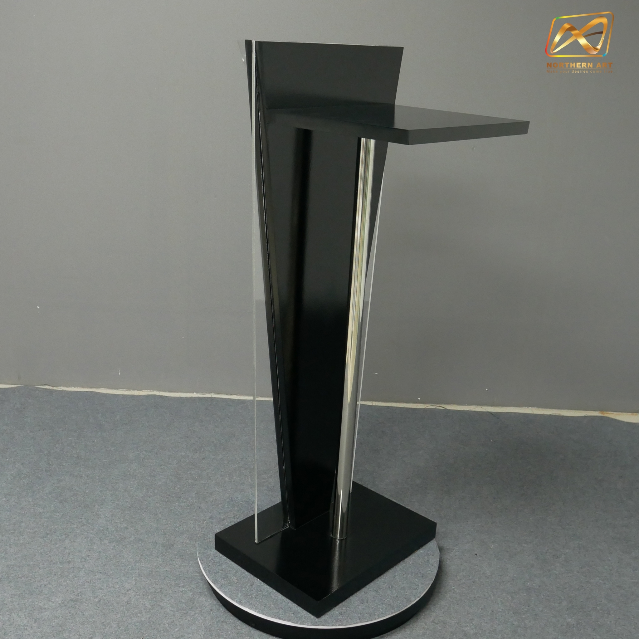 โพเดียมไม้สีดำ ทรงสามเหลี่ยม ขนาด (W) 45 x (L) 35 x (H) 120 cm. ด้านข้างอะคริลิคใส หนา 8 มม. ด้านหน้าอะคริลิคใส ติดหมุด สำหรับติดโลโก้